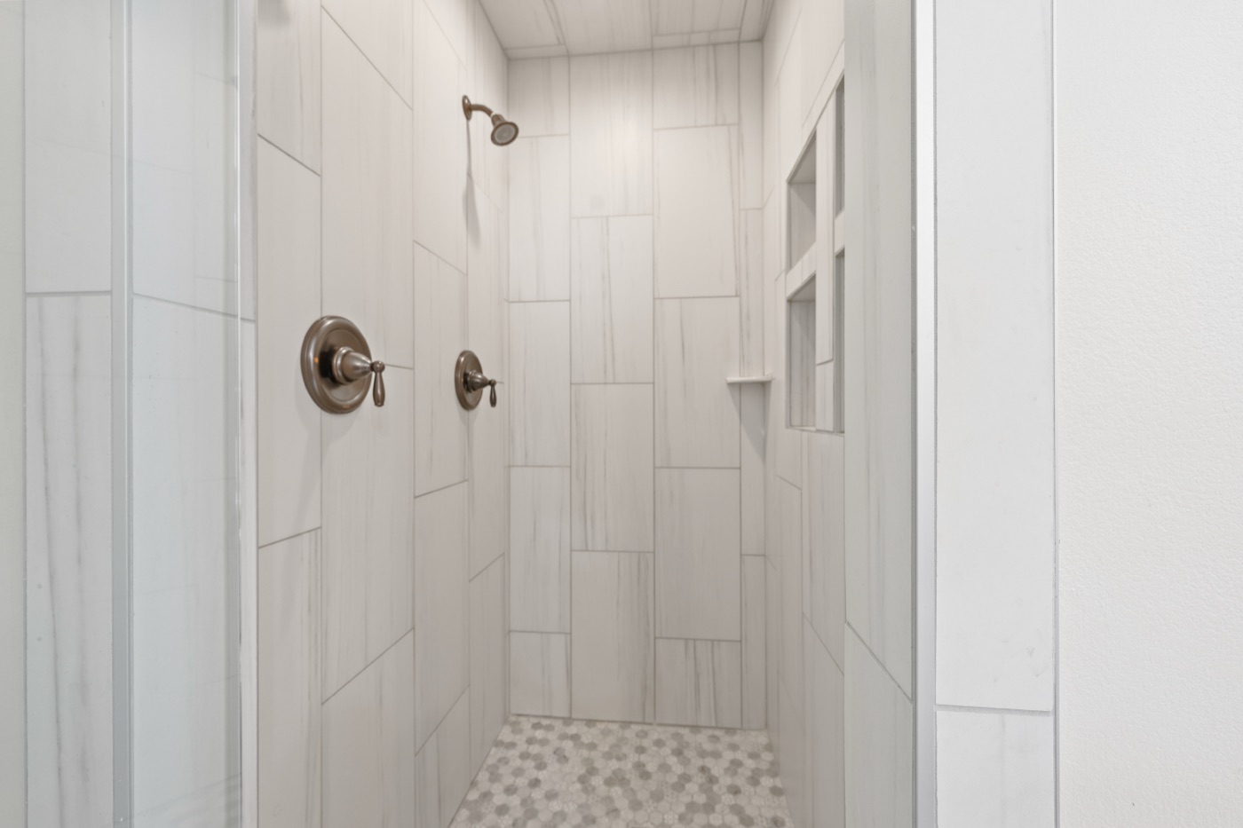 Frameless glass shower with marble tile